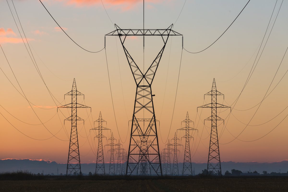High-voltage transmission towers at sunrise
